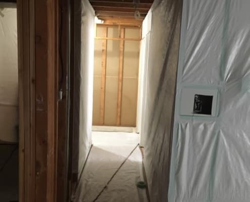 Asbestos abatement progress in Kitsilano home hallway